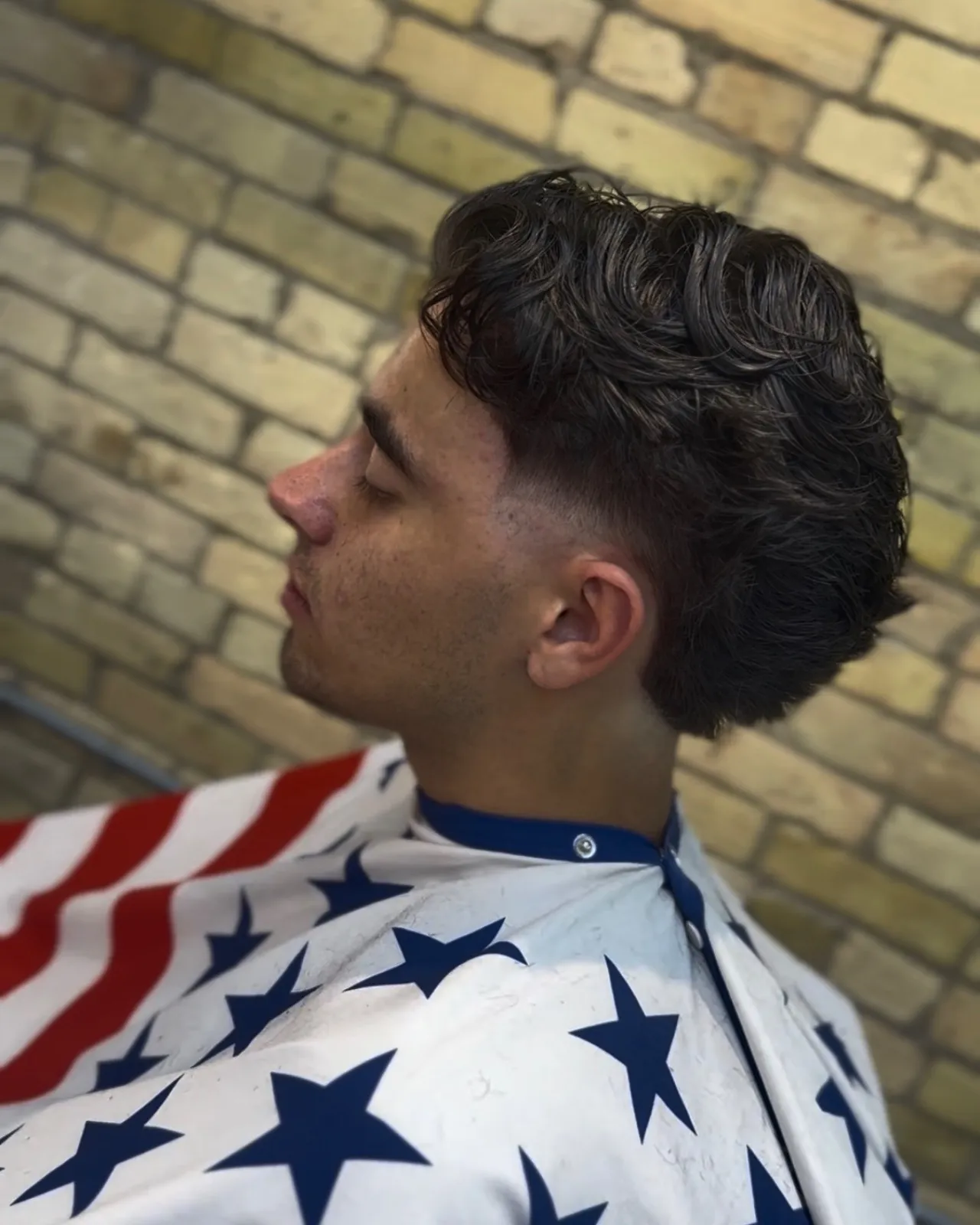Burst fade with middle part and textured top by Gilberto, barber at Studio AZ Barbershop in Minneapolis.